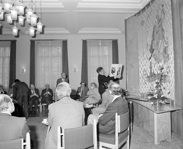 884054 Afbeelding van burgemeester H.J.L. Vonhoff die een geschenk toont (portretfoto's van hemzelf en zijn echtgenote) ...